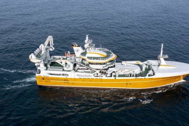 Large fishing vessel with gear and equipment in open sea, commercial fishing industry publication.
