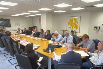 Fishing industry meeting with fishermen and industry reps in a conference room, commercial fishing.