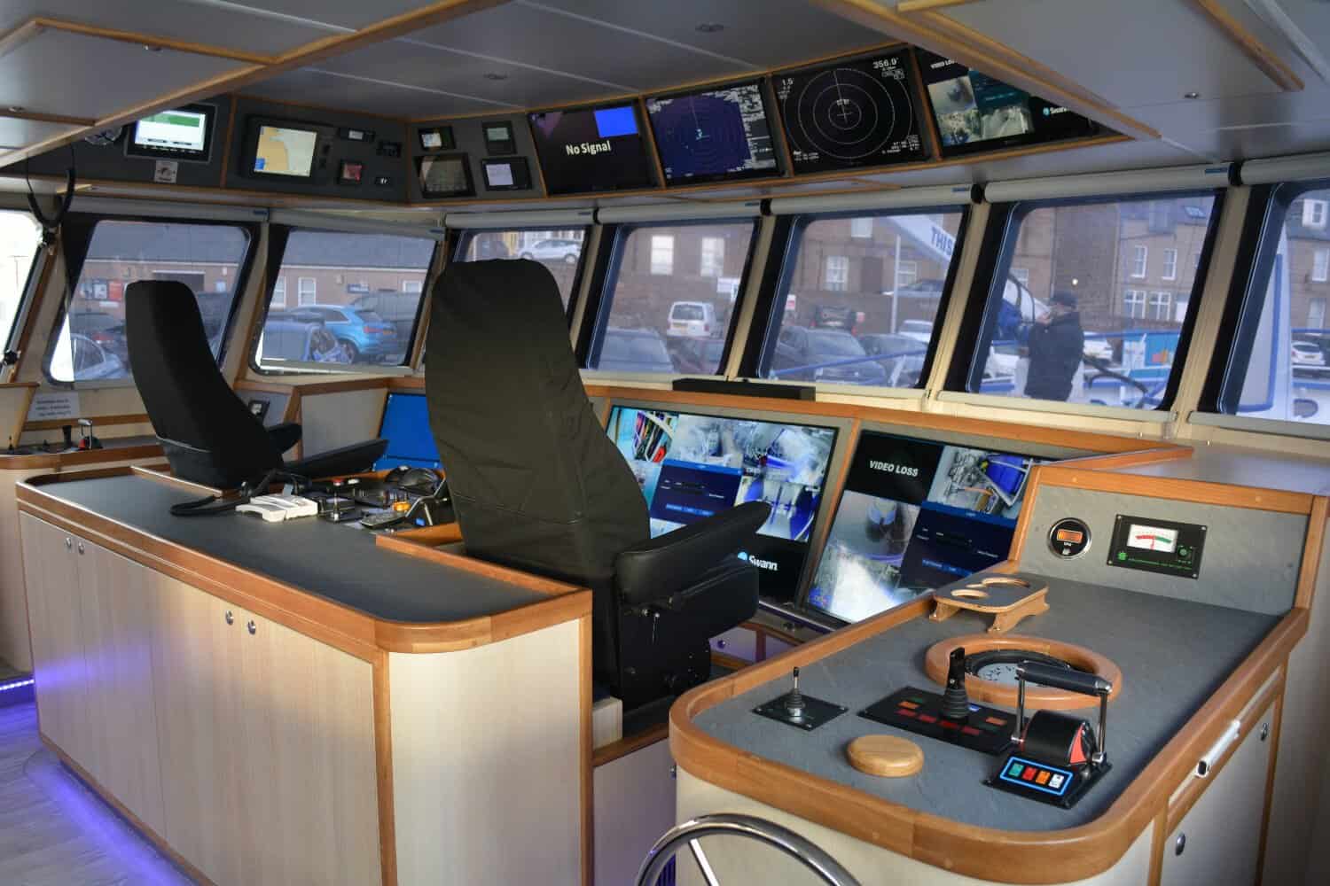 Inside the bridge of a fishing vessel with navigation and communication equipment for commercial use.