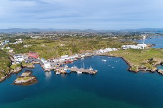 Aerial view of a fishing port with fishing vessels, industry equipment, and coastal infrastructure,.