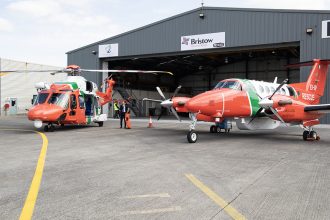 Irish Coast Guard helicopters at a port with fishing vessels in the background, industry equipment,.
