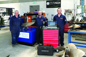 Commercial fishing industry publication: fishermen with fish testing equipment in workshop, industry.