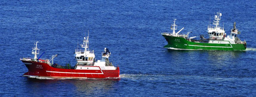 Two fishing vessels at sea, commercial fishing boats with gear and industry equipment.