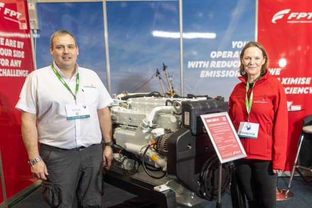 Two people at DSD Marine Solutions Ltd Open Day with marine engine display.
