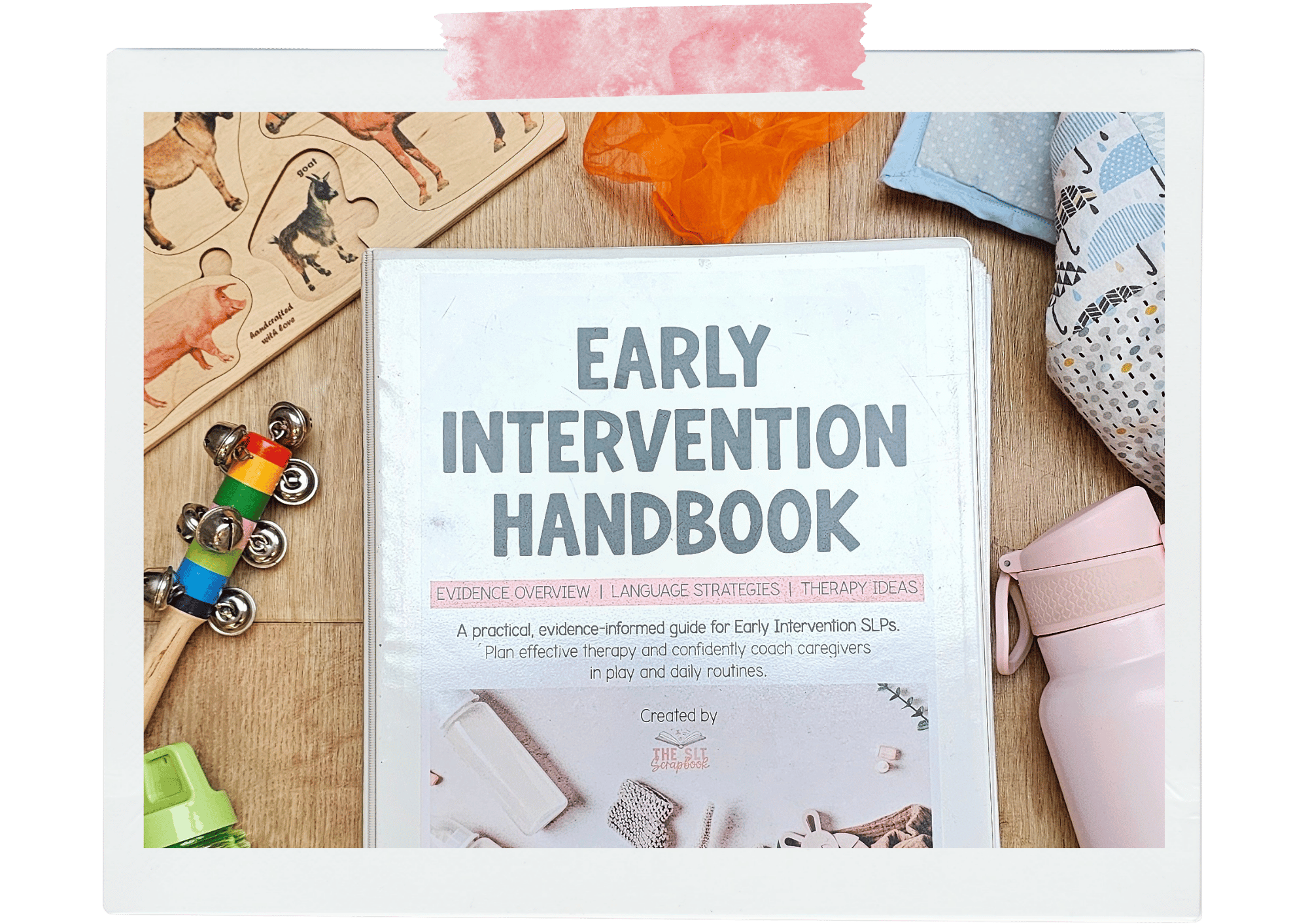 Image showing the Early Intervention Handbook resources surrounded by various other toys, as well as blankets and a water bottle.