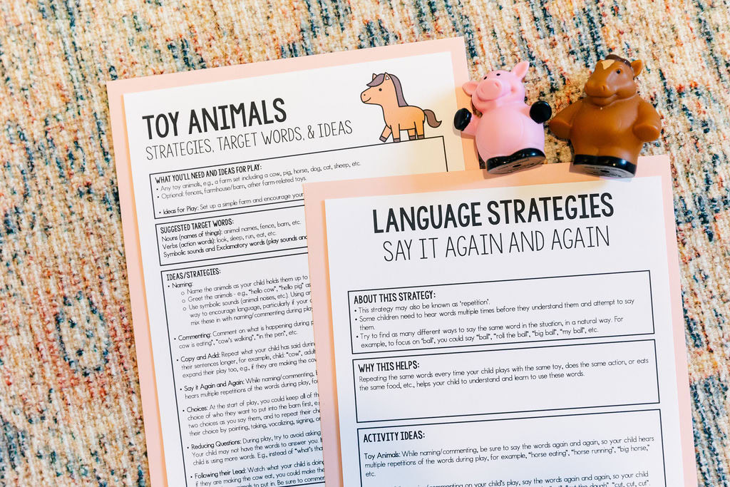 Two early language handouts- one for toy animals and one about the say it again and again strategy are arranged on the floor. Two toy animals are next to the handouts.