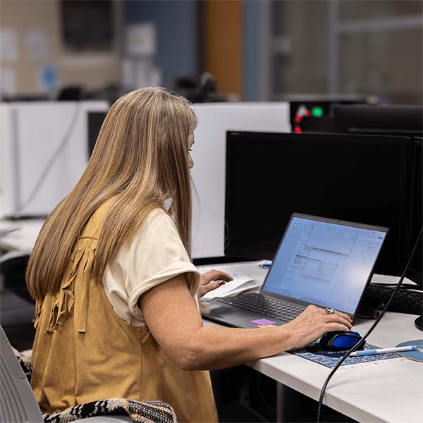 student typing on laptop