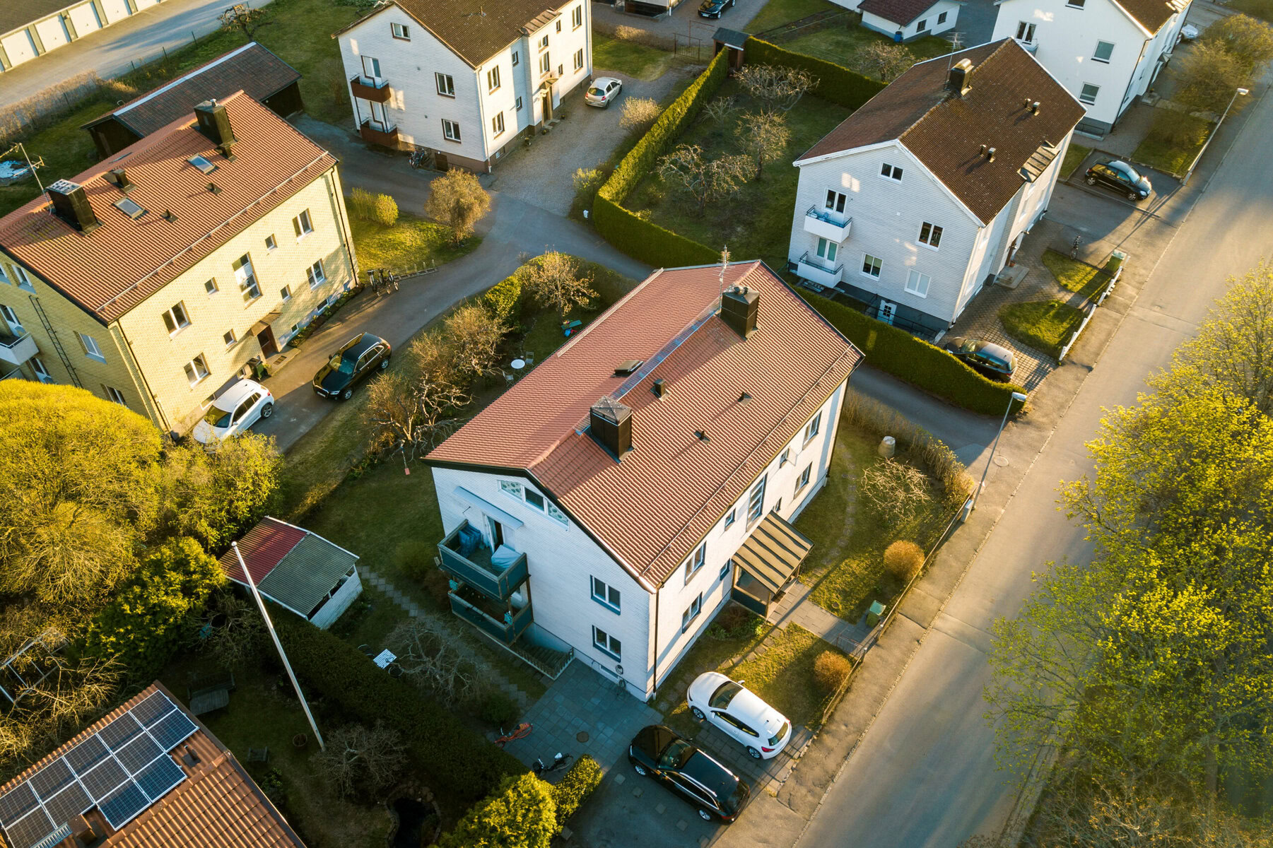 Aerial view of a residential neighborhood with several houses and cars.