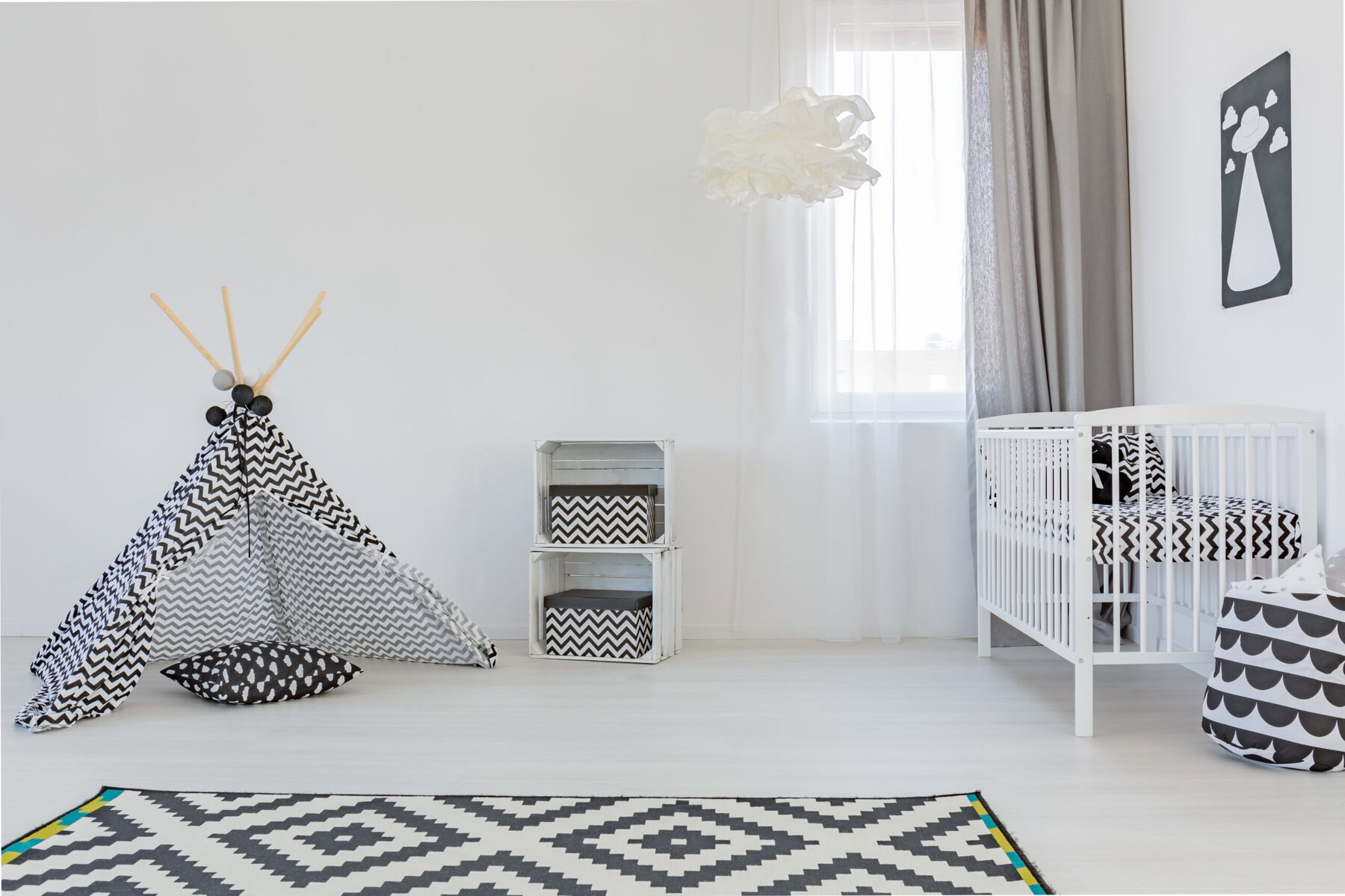 Monochromatic nursery with a play tent, crib, and geometric patterns