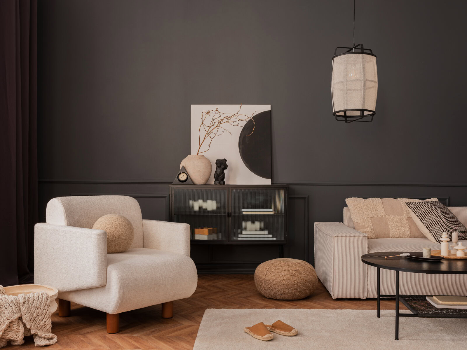 Modern living room with neutral tones, armchair, sofa, and decorative accents.