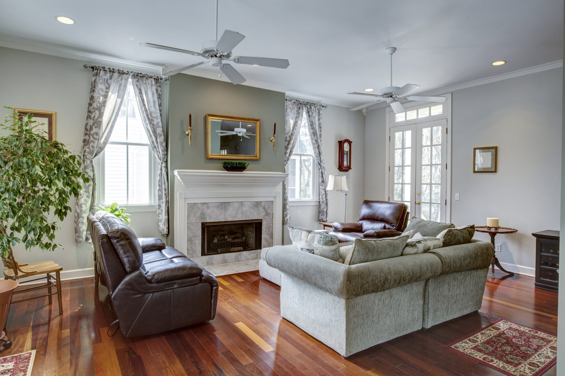 Spacious living room with fireplace, two sofas, and ceiling fans.