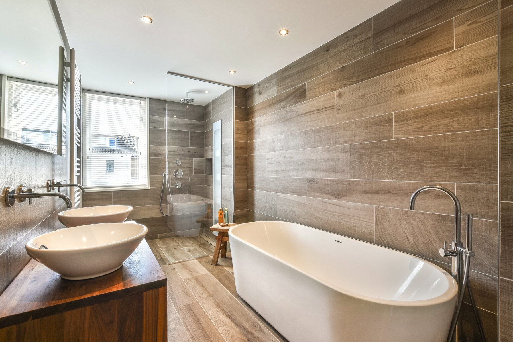 Modern bathroom with double sinks, a freestanding tub, and a glass shower.