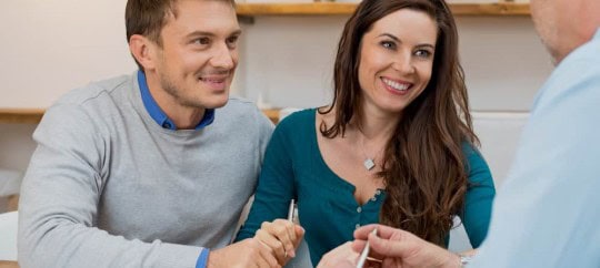 Happy couple consulting with financial advisor at Trust Point.