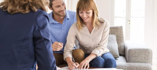 Happy clients discussing documents with a consultant at Trust Point.