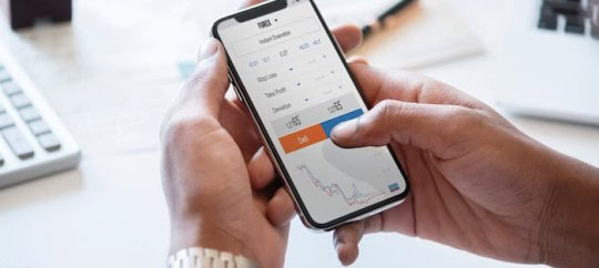 Person analyzing financial data on smartphone with stock charts and graphs.