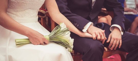 Bride and groom holding hands during wedding ceremony at Trust Point.