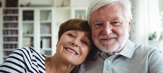 Happy senior couple smiling in a cozy home environment.