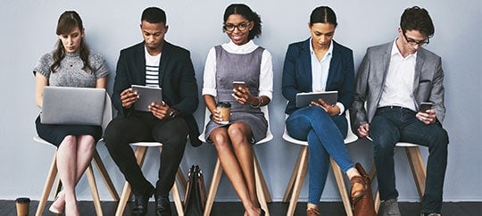 Business team using laptops and tablets in a modern office setting.