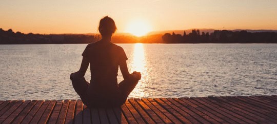 Woman Sitting On The Pier And Watching The Sunset