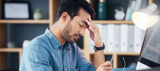 man with laptop looking frustrated
