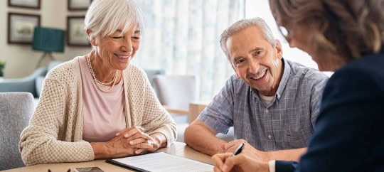 Elderly couple consulting with financial advisor about transitioning finances.