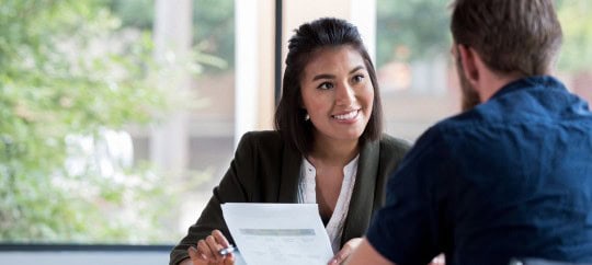 Financial professional smiling and talking while meeting with a financial professional