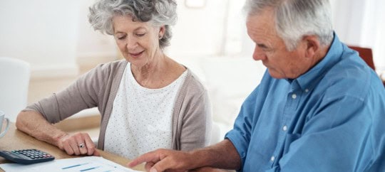 retired couple looking at financial and investment information