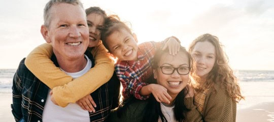 Family smiling while on the beach