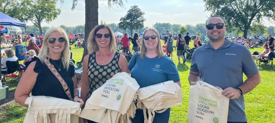Trust Point team members at Riverside event with bags and smiling faces.