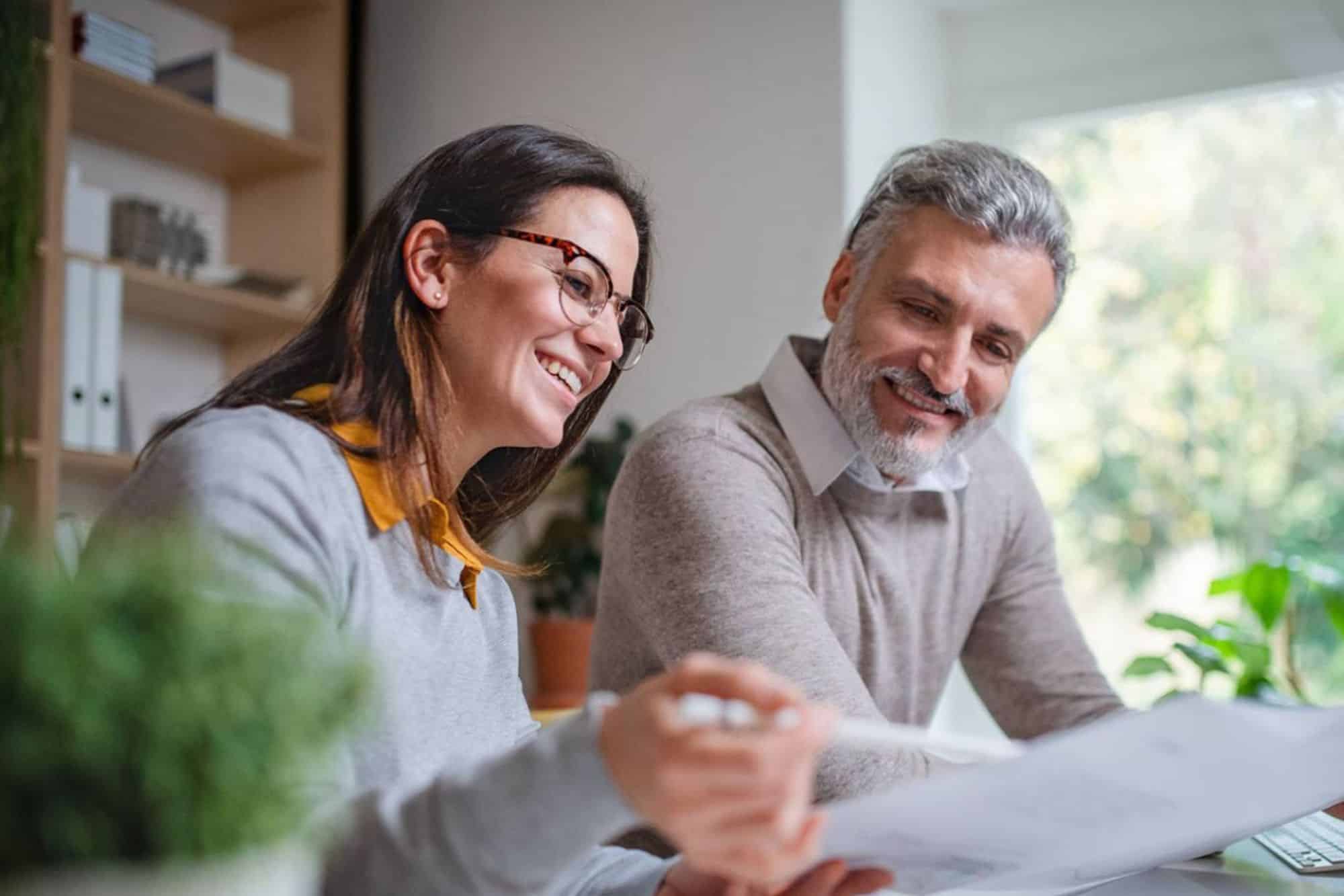 Two financial advisors discussing documents for financial planning.