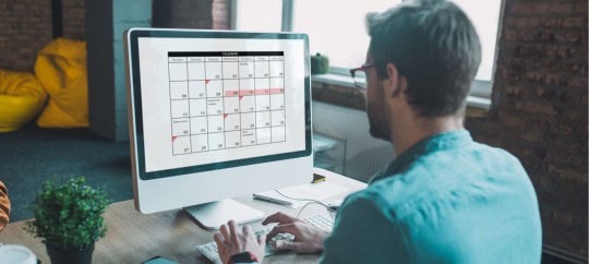 Man looking at a calendar on the computer