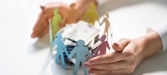 Paper cutouts of people gathered around money representing philanthropy