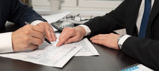Two business professionals lookig at tax papers