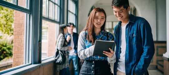 2 College students looking at a tablet