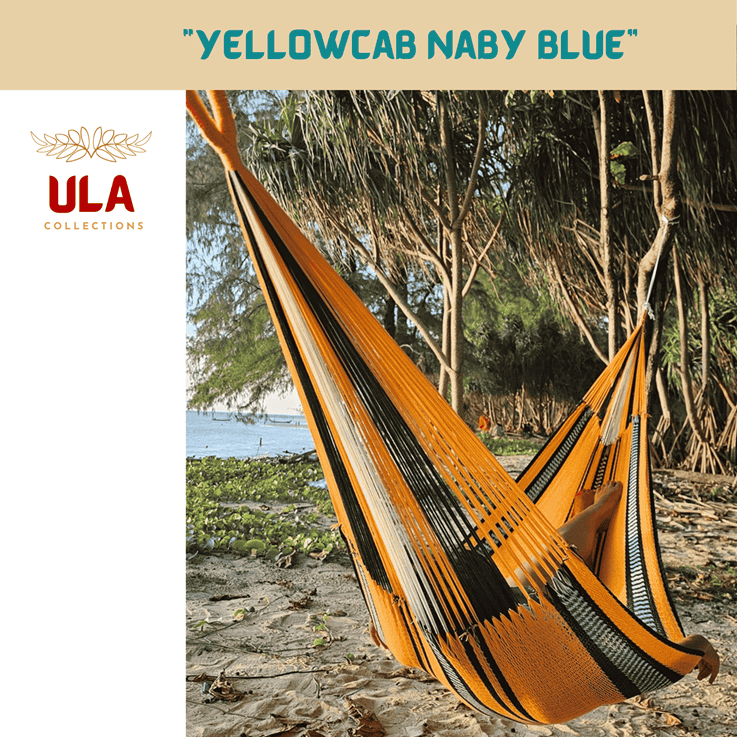 ULA Collections "Yellow Cab Navy Blue" woven acrylic yarn hammock, featuring stripes of golden yellow, navy blue, and white, hung on a tropical beach.