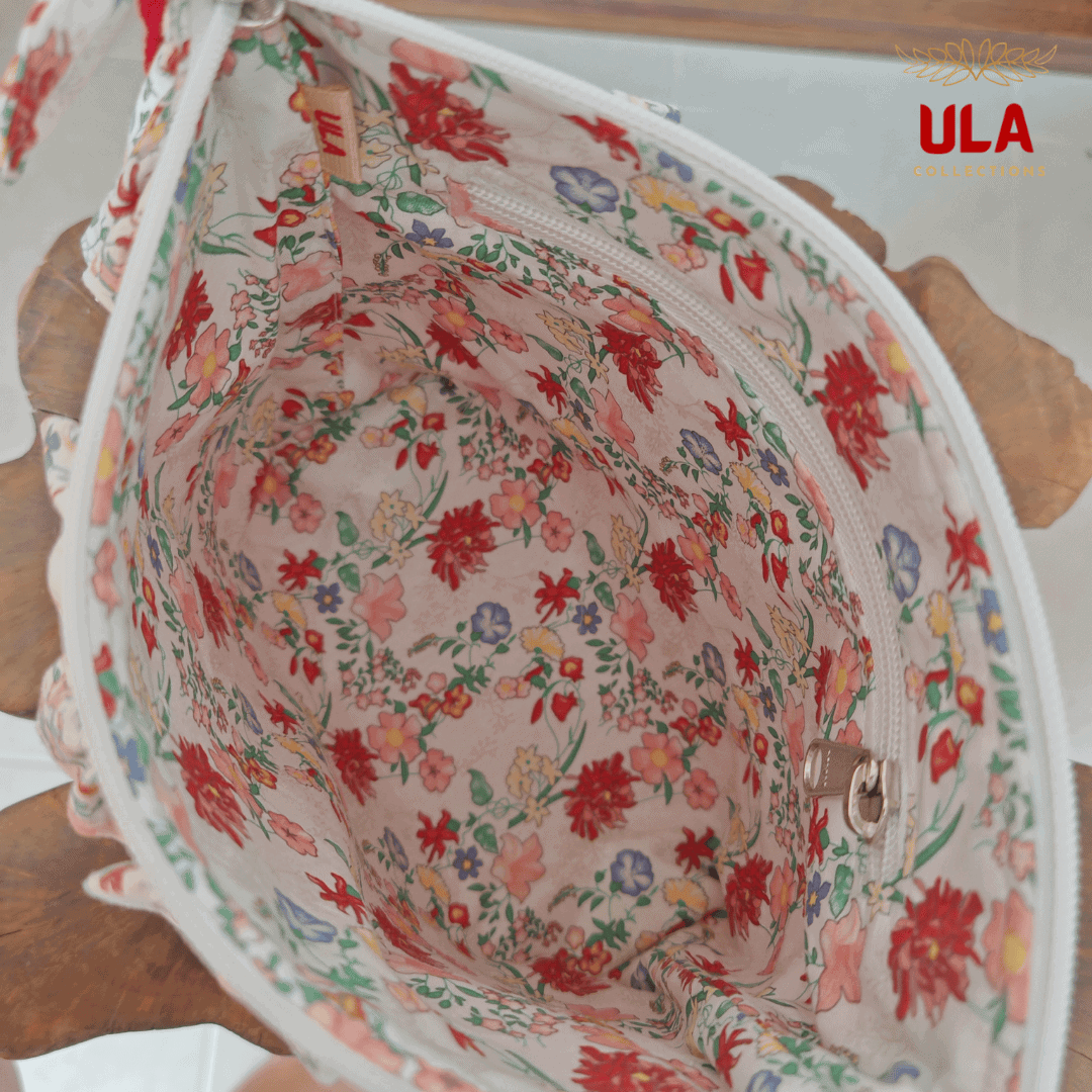 Interior view of a spacious floral-lined travel pouch with a built-in zippered pocket and an authentic ULA brand tag, highlighting the high-quality textile design.