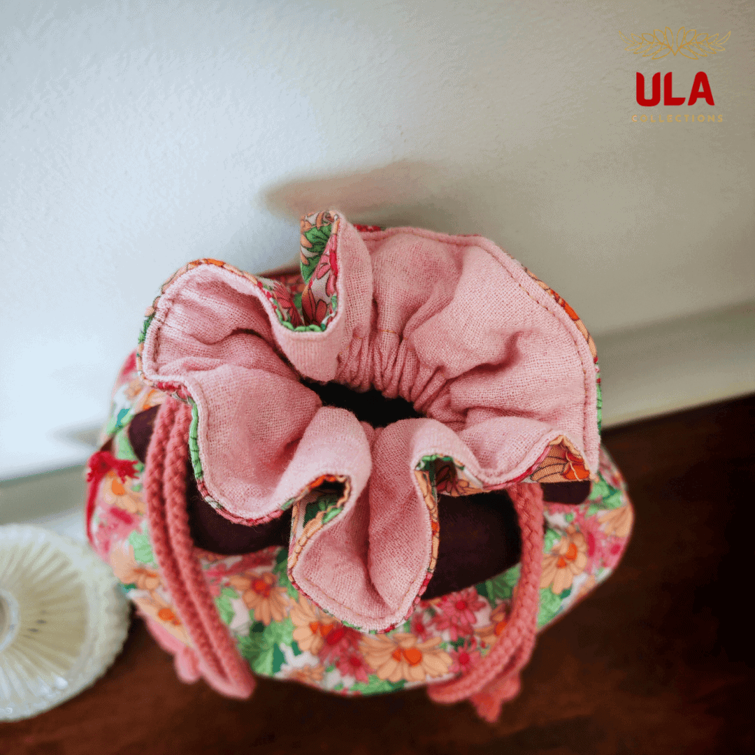A top-down view looking into the open bag, showcasing a soft, light pink textured interior lining. The ruffles of the floral exterior and burgundy collar frame the pink opening.