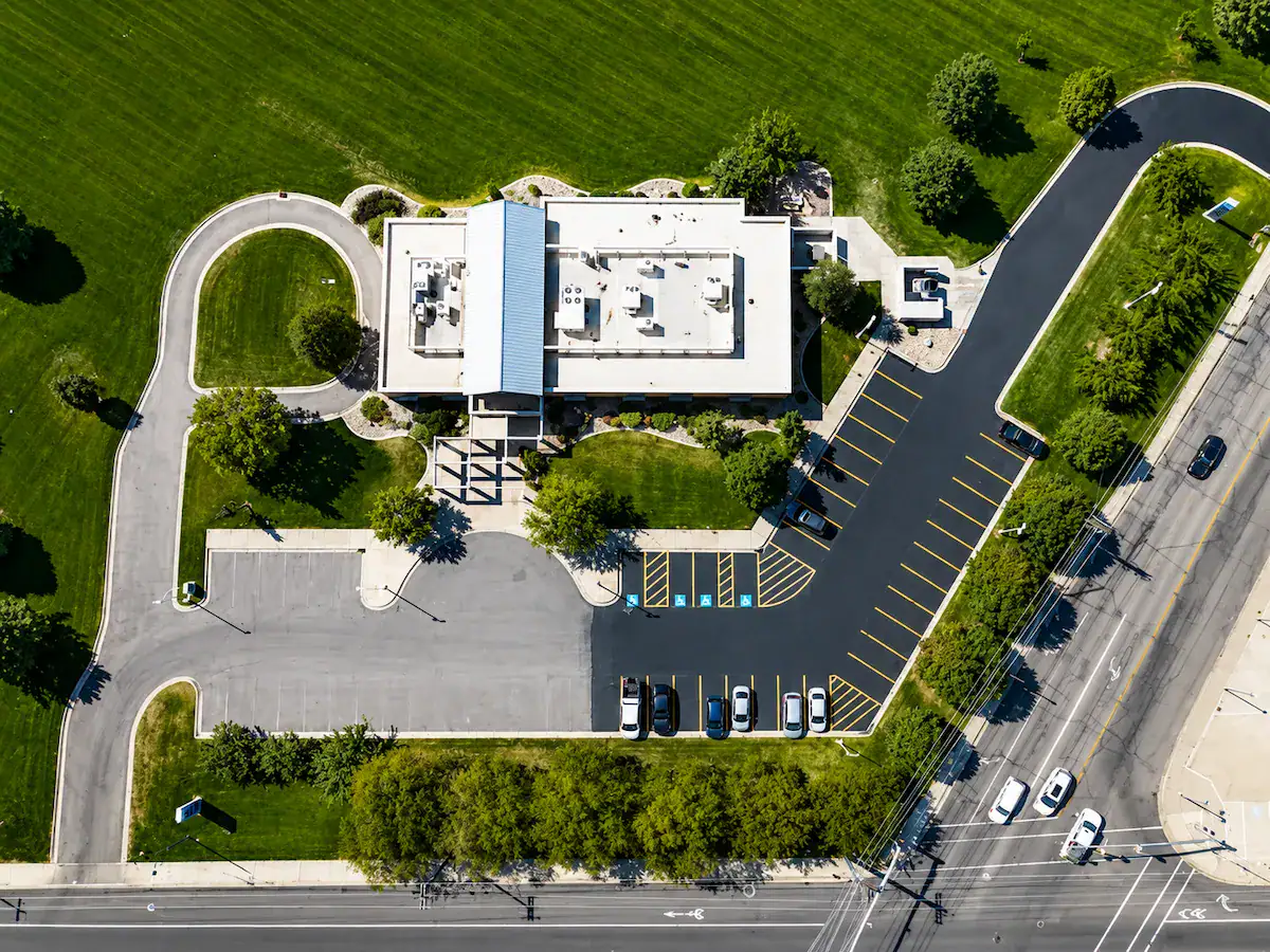 Aerial view of a freshly paved commercial parking lot and roadway in Utah