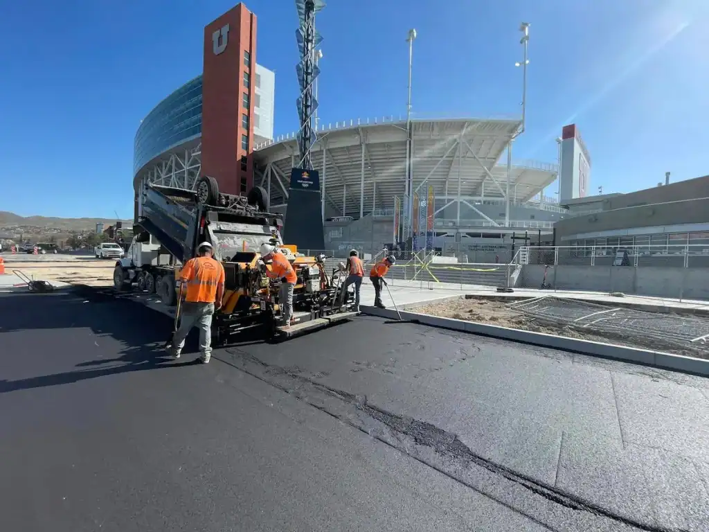 Crew working on a parking lot project near a Utah stadium