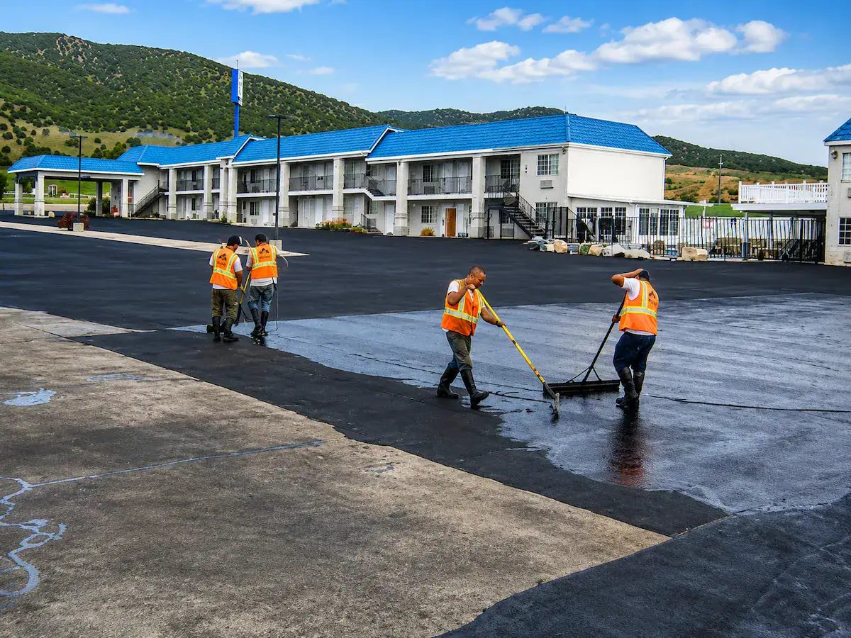 Sealcoating crew applying fresh asphalt sealcoat to a commercial parking lot in Utah
