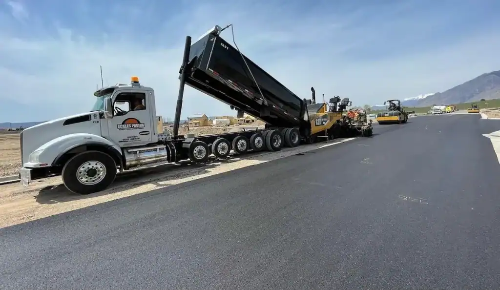 Paver laying asphalt on a private road with a mountain backdrop