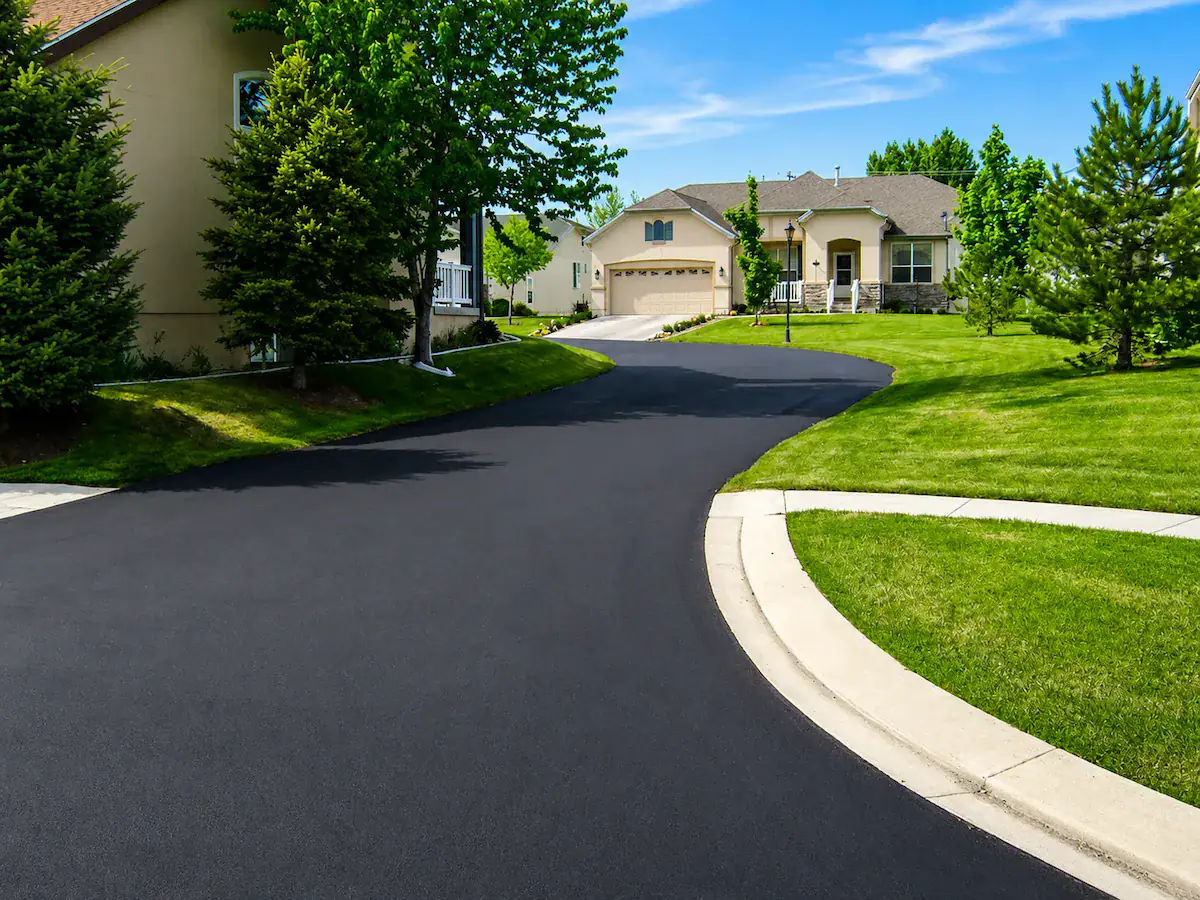 Freshly sealcoated residential asphalt driveway in a clean Utah neighborhood