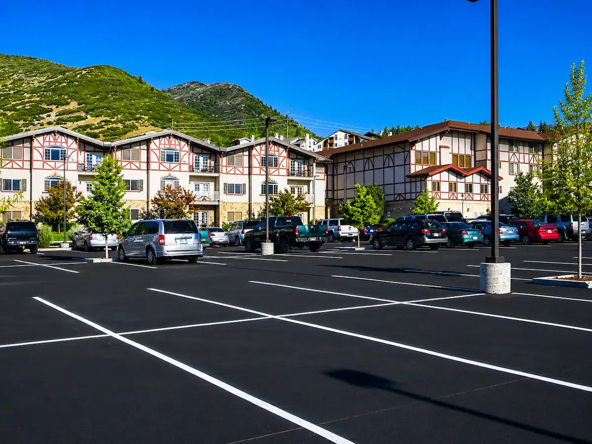 Freshly sealcoated apartment complex parking lot with mountain backdrop in Utah