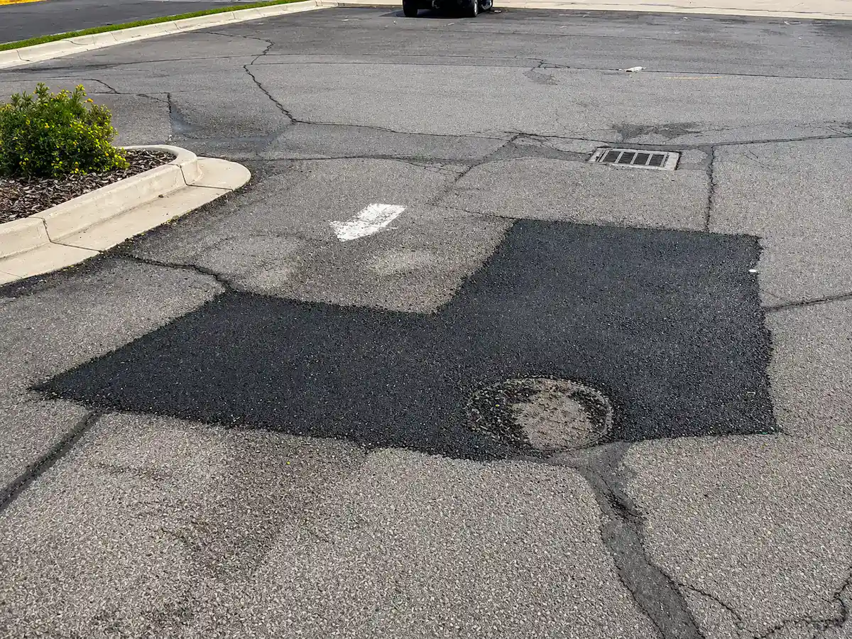 Professional asphalt patching repair completed in a Utah parking lot to restore damaged pavement and improve surface durability.