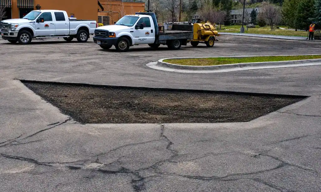 Commercial asphalt patching excavation area prepared for pavement repair in Utah parking lot