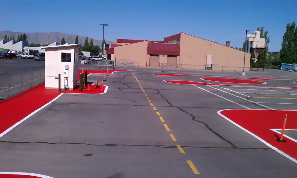 High-visibility red safety zone striping in a Utah commercial parking lot