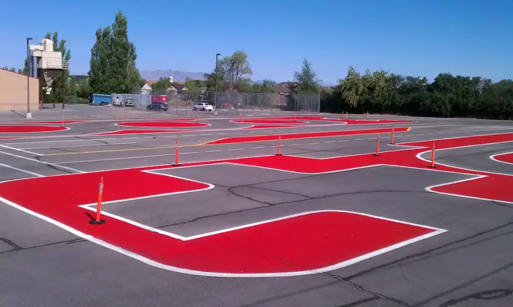 Red safety zone pavement markings in a Utah commercial parking lot