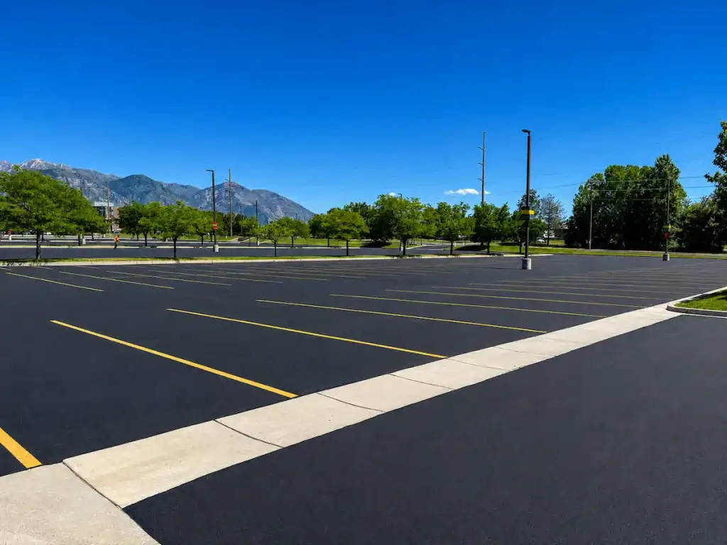 Freshly paved commercial parking lot in Salt Lake City, Utah with smooth asphalt surface and mountain views.