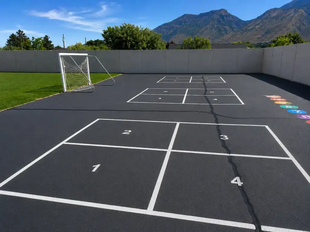 After photo of freshly sealcoated playground with bright new four square court markings at Timpanogos Academy in Lindon, Utah.
