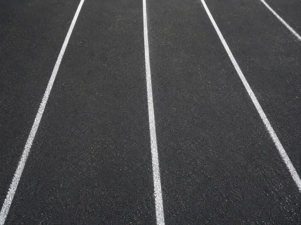 After photo of freshly sealcoated running track with bright new lane striping at Timpanogos Academy in Lindon, Utah.